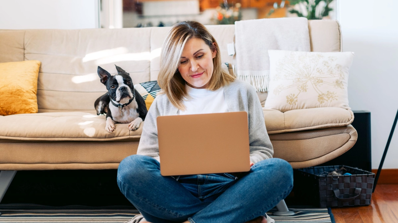 Frau mit Hund am Laptop im Homeoffice