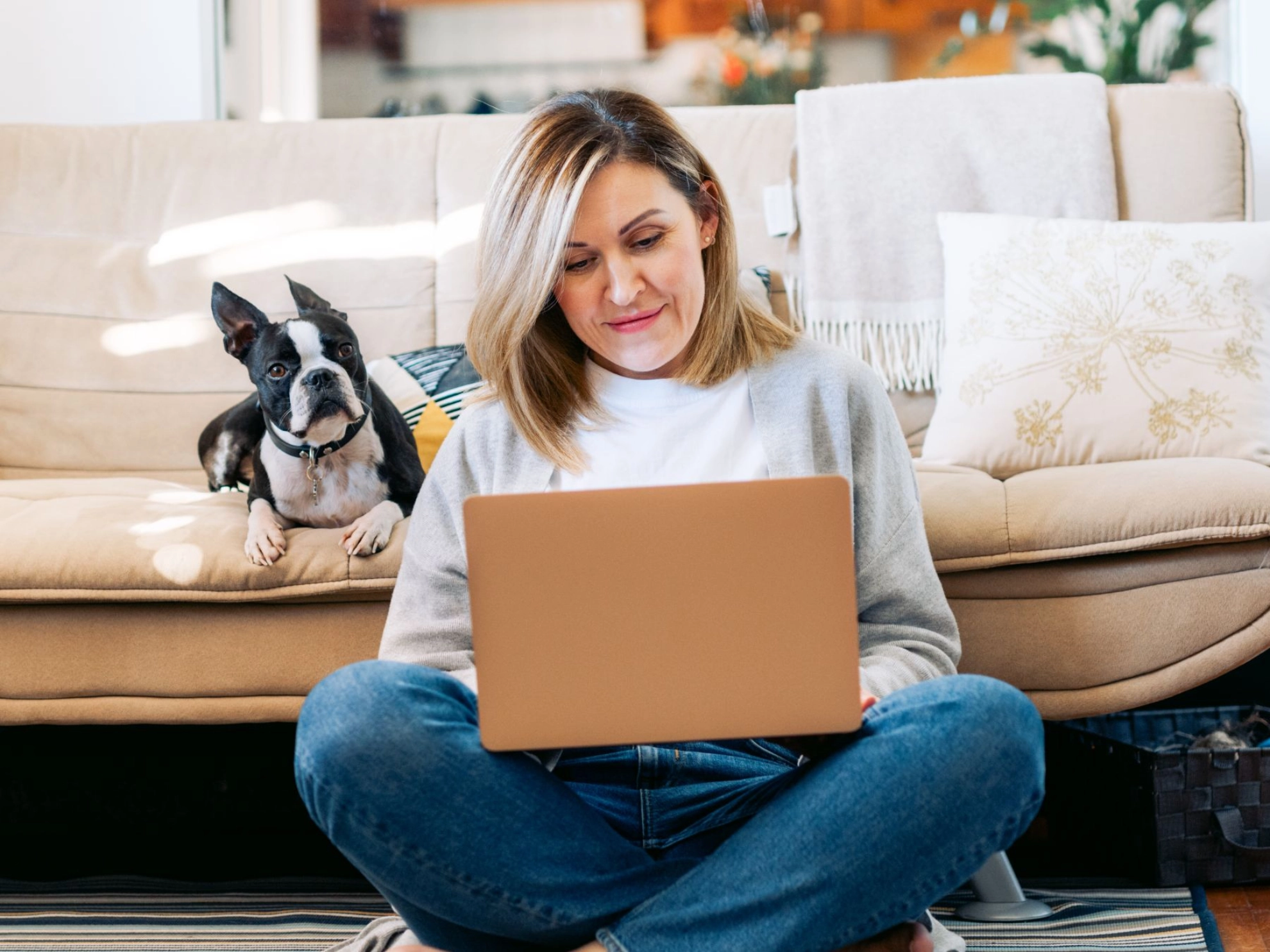 Frau mit Hund am Laptop im Homeoffice