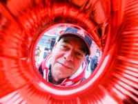 Ein Mann mit IG Metall-Kappe schaut durch einen runden Luftballon.